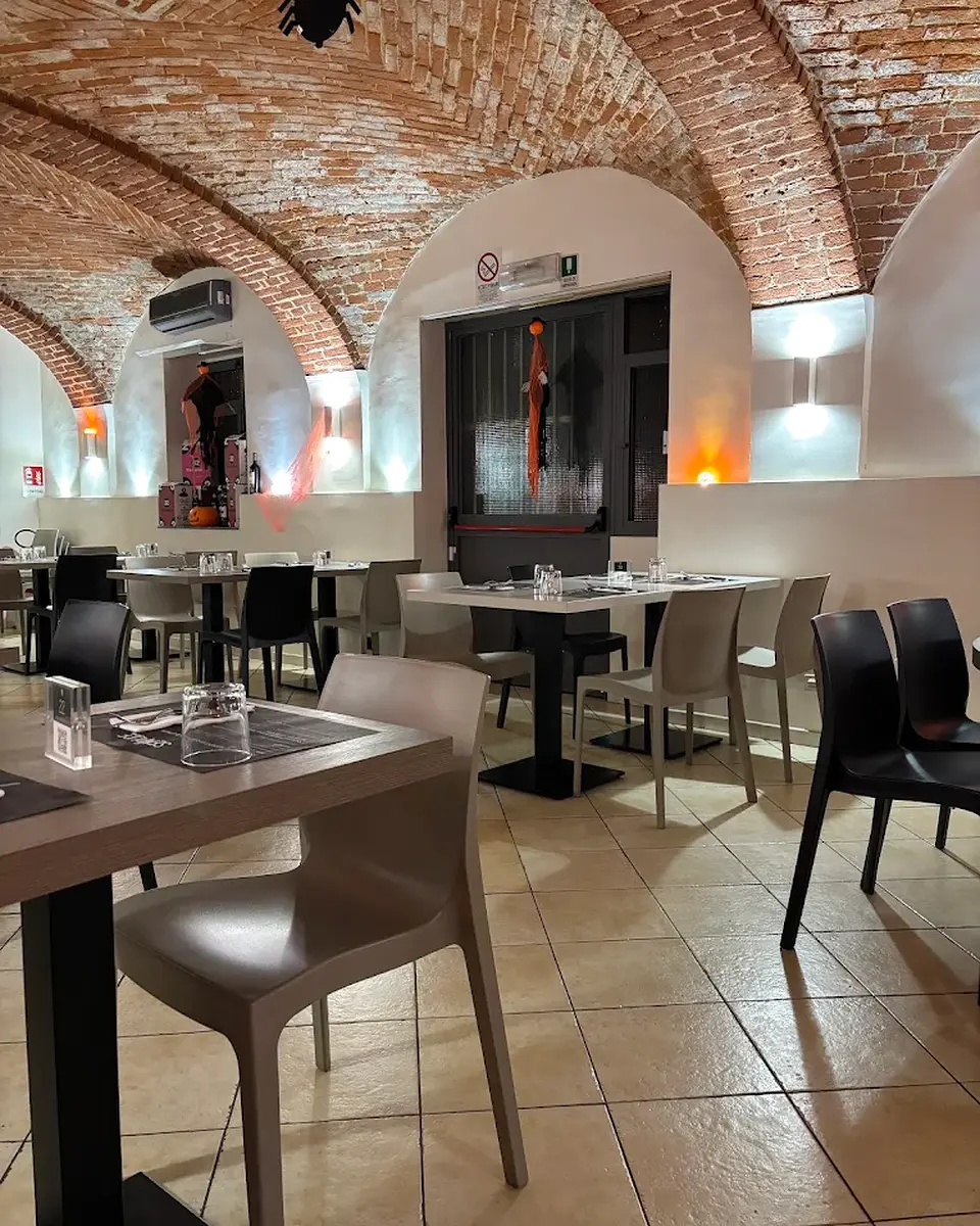 La sala interna di Semplice Pizzeria a Orbassano, con volte in mattoni e tavoli apparecchiati